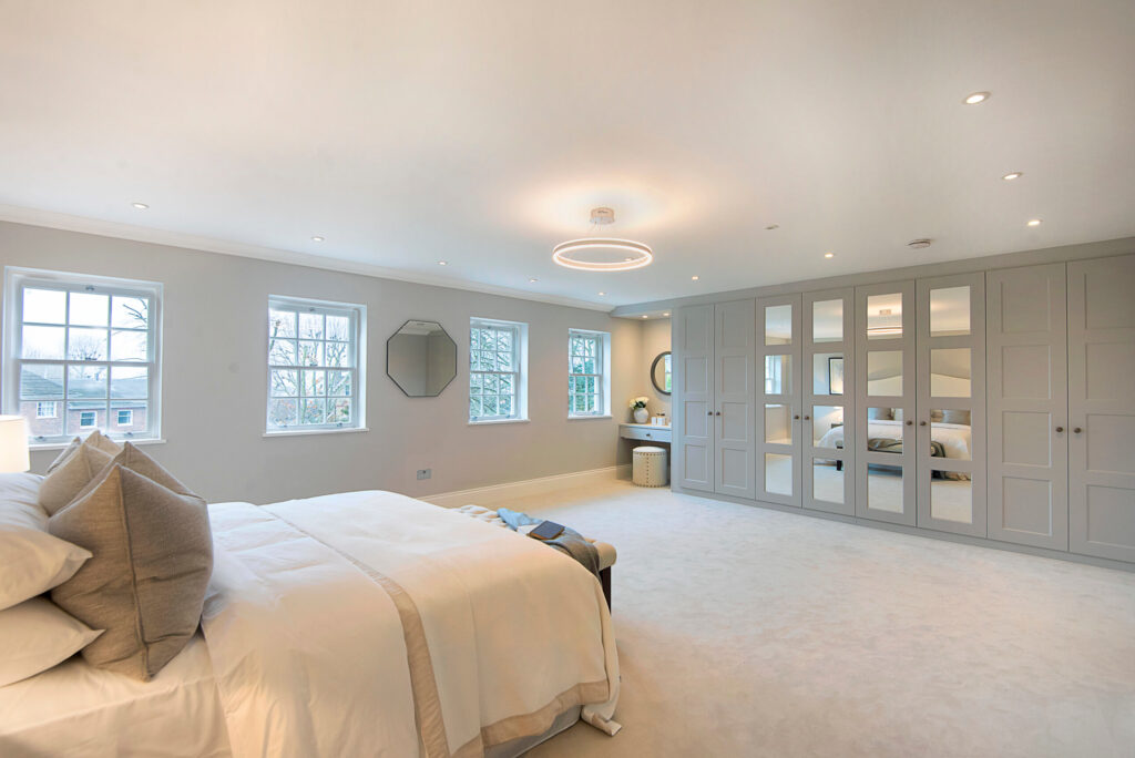 Light and airy bedroom designs with a bed in the bottom left corner and built in wardrobes on the right.